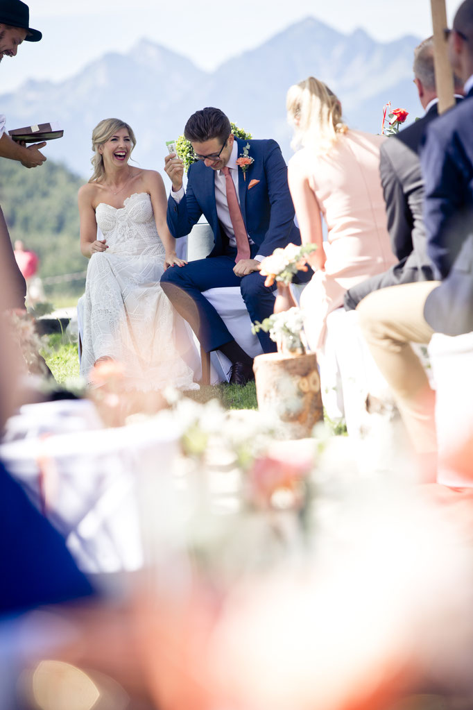 Braut und Bräutigam lachen während der Trauzeremonie