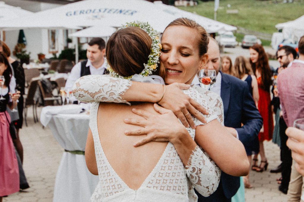 Eine glückliche Braut umarmt ihre Traurednerin von Strauß & Fliege