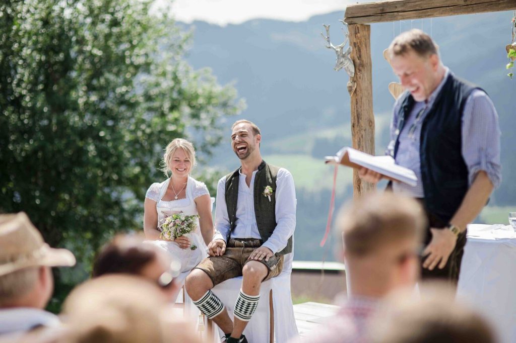 Lachendes Brautpaar in bayerischer Tracht bei seinen freien Trauung