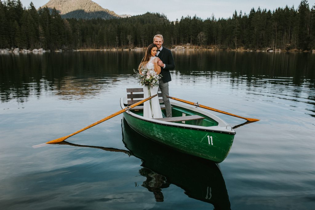 Ein Brautpaar im Ruderboot auf einem Gebirgssee