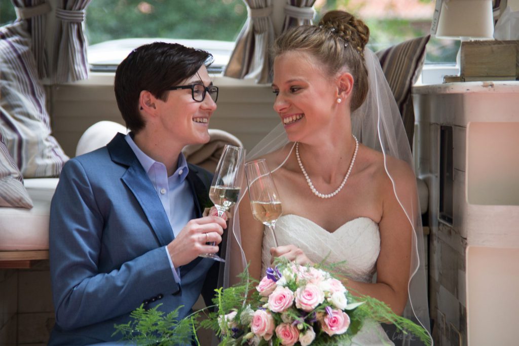 Ehe für Alle - Braut und Braut stoßen an auf Ihre Hochzeit | Strauß & Fliege