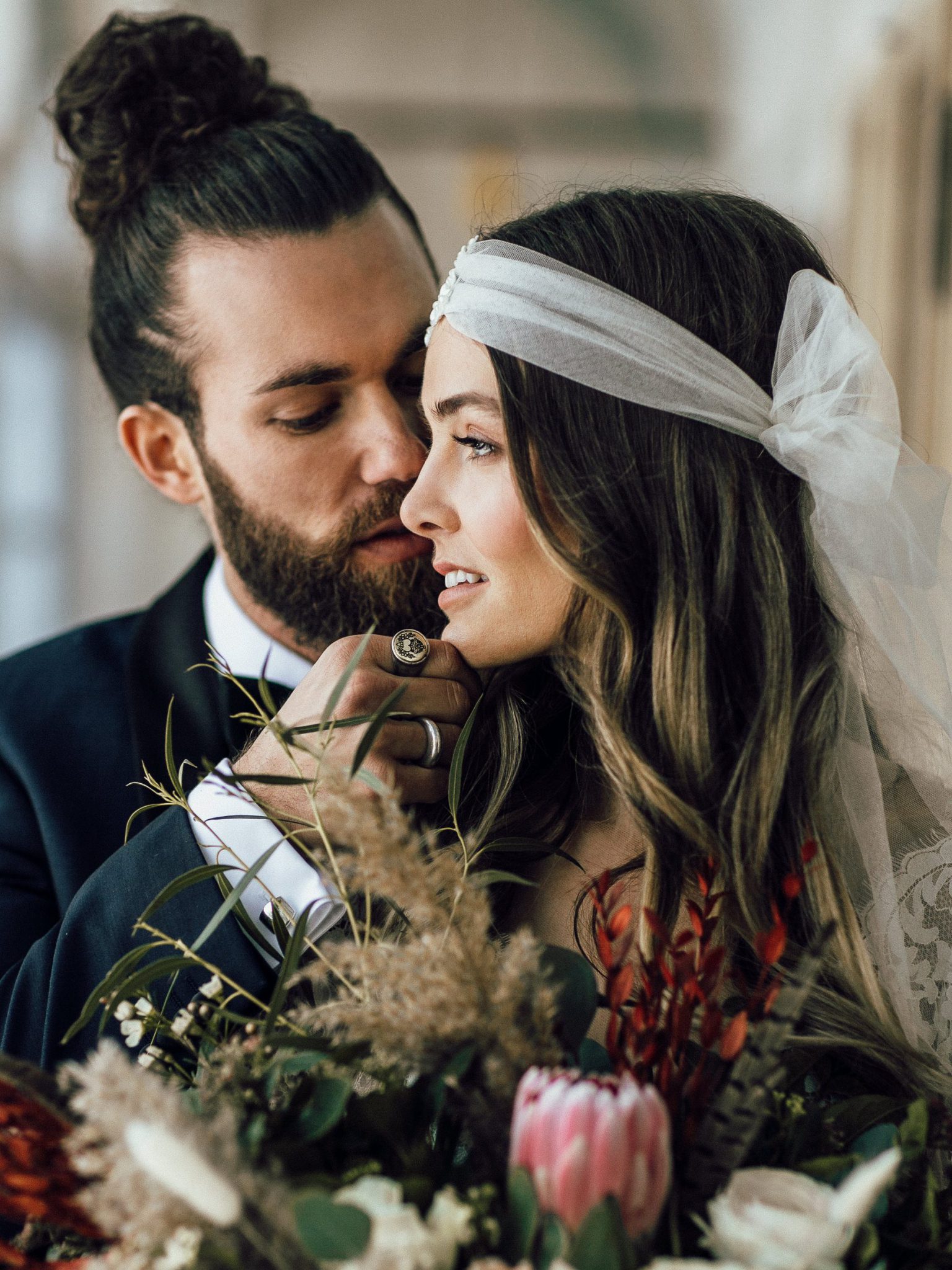 Braut mit Kopfschmuck und Blumen und Bräutigam