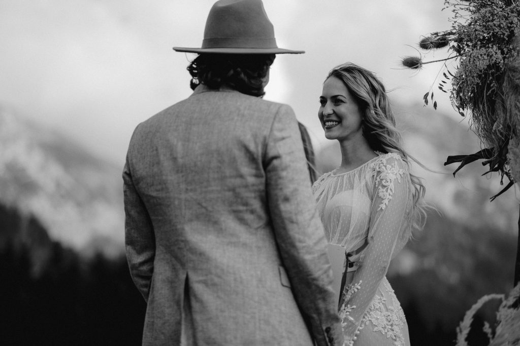 Strahlendes Boho Brautpaar bei der Hochzeit in den Alpen