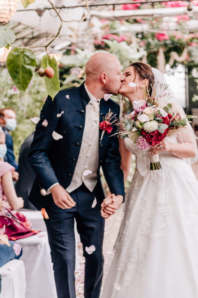 Brautpaar küsst sich nach der Trauzeremonie alte Gärtnerei München