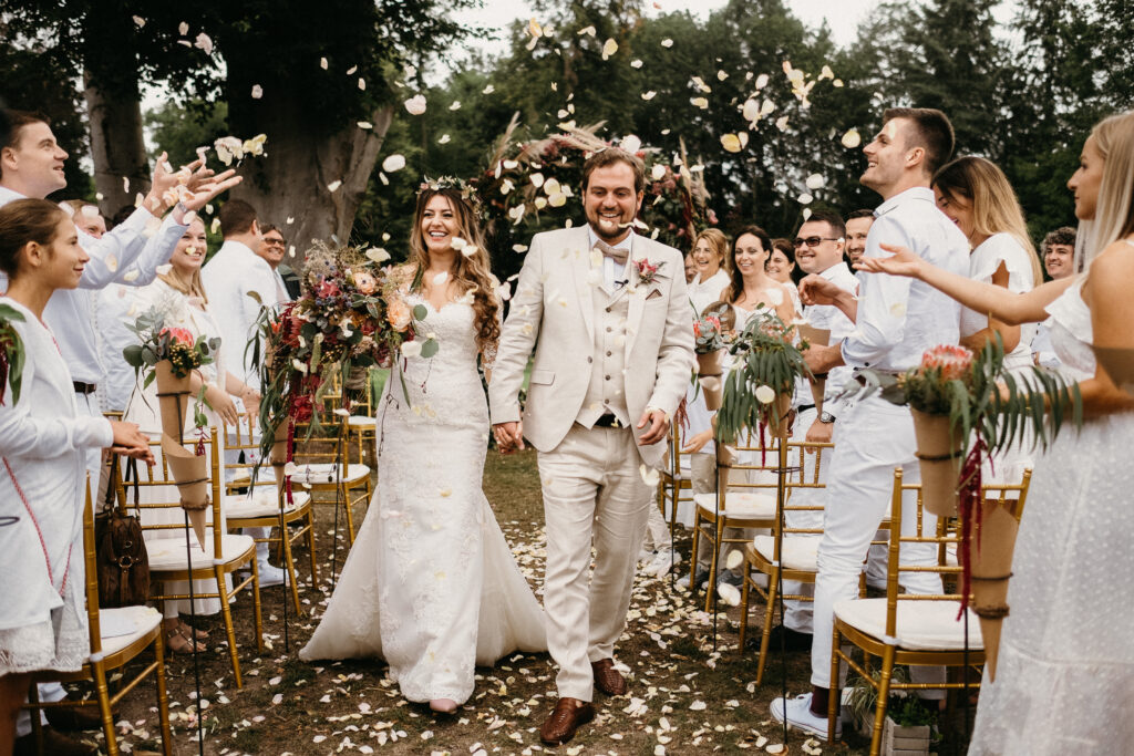 Hochzeit Schloss Reichmannsdorf Brautpaar beim Auszug nach der Zeremonie im Blumenregen | Strauß & Fliege