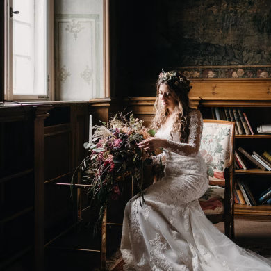 Boho Braut in moderner Spitze und wildem Blumenstrauß
