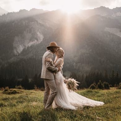 Boho Brautpaar in den Alpen bei Sonnenuntergang