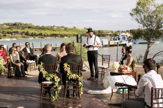 Outdoor wedding ceremony with guests seated by the water
