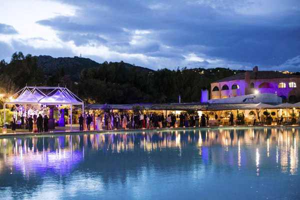 Wedding venue illuminated beside a pool at night