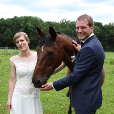 Brautpaar mit Pferd bei DIY Hochzeit in einer Scheune